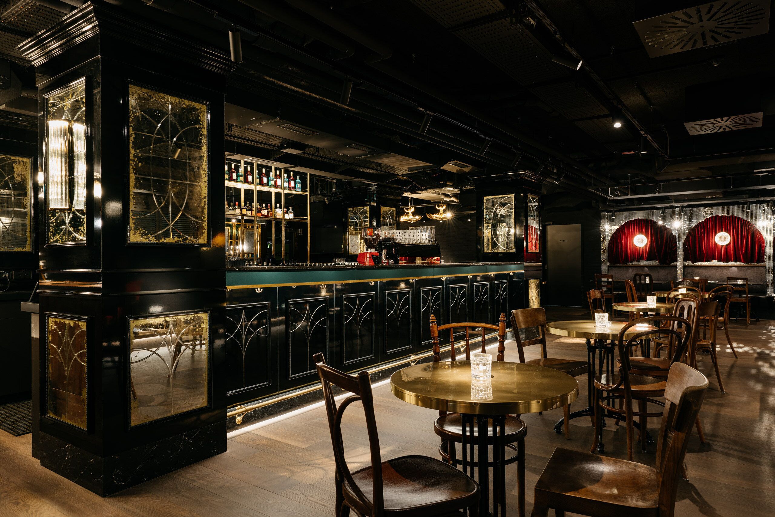 Eine Bar mit Tresen, Stühlen und Tischen.