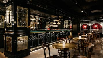 Eine Bar mit Tresen, Stühlen und Tischen.