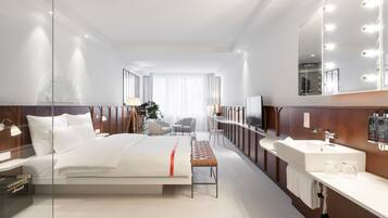 A modern hotel room with a large bed, a vanity with a mirror, and a seating area with chairs.