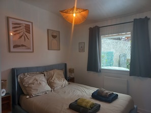 Cozy retreat with a large bed, framed artworks, and a unique ceiling light.