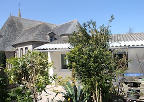 Traditional European-style building surrounded by a well-maintained garden with lush plants.
