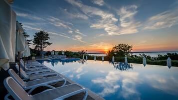 Een seizoensgebonden buitenzwembad, parasols voor strand/zwembad