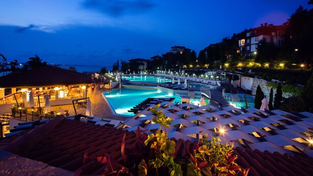 A resort with a large swimming pool, lounge chairs, and a bar area. - Viva Mare Beach Hotel (Sozopol)