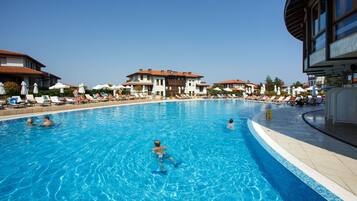 Een seizoensgebonden buitenzwembad, parasols voor strand/zwembad