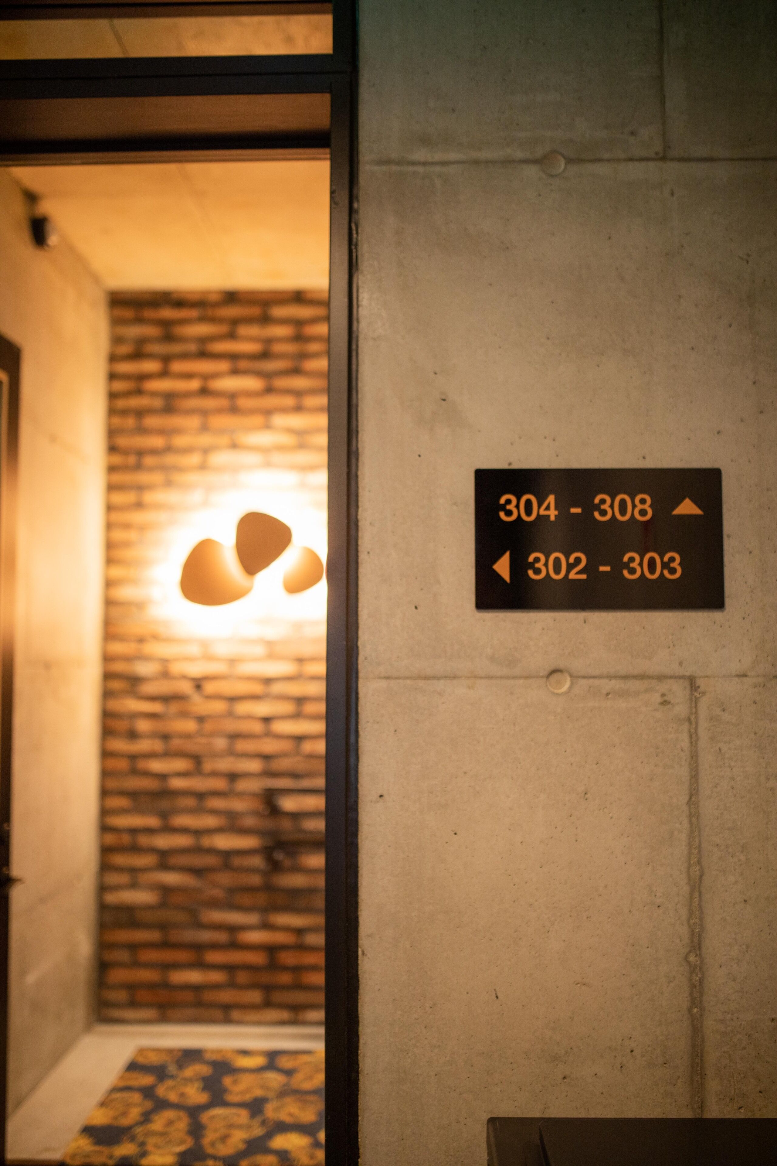 Ein Hotelinnenraum mit einem Schild, das die Zimmernummern 304 bis 308 und 302 bis 303 anzeigt.