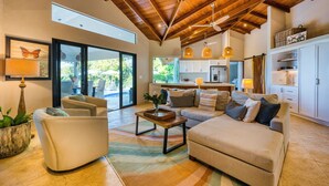 A spacious living area with a high ceiling, a sofa, a coffee table, and a view of the kitchen. - NEWLY REMODELED GRAND OPENING PRICING
4 Bedroom villa (Uvita, Ballena, Puntarenas,)