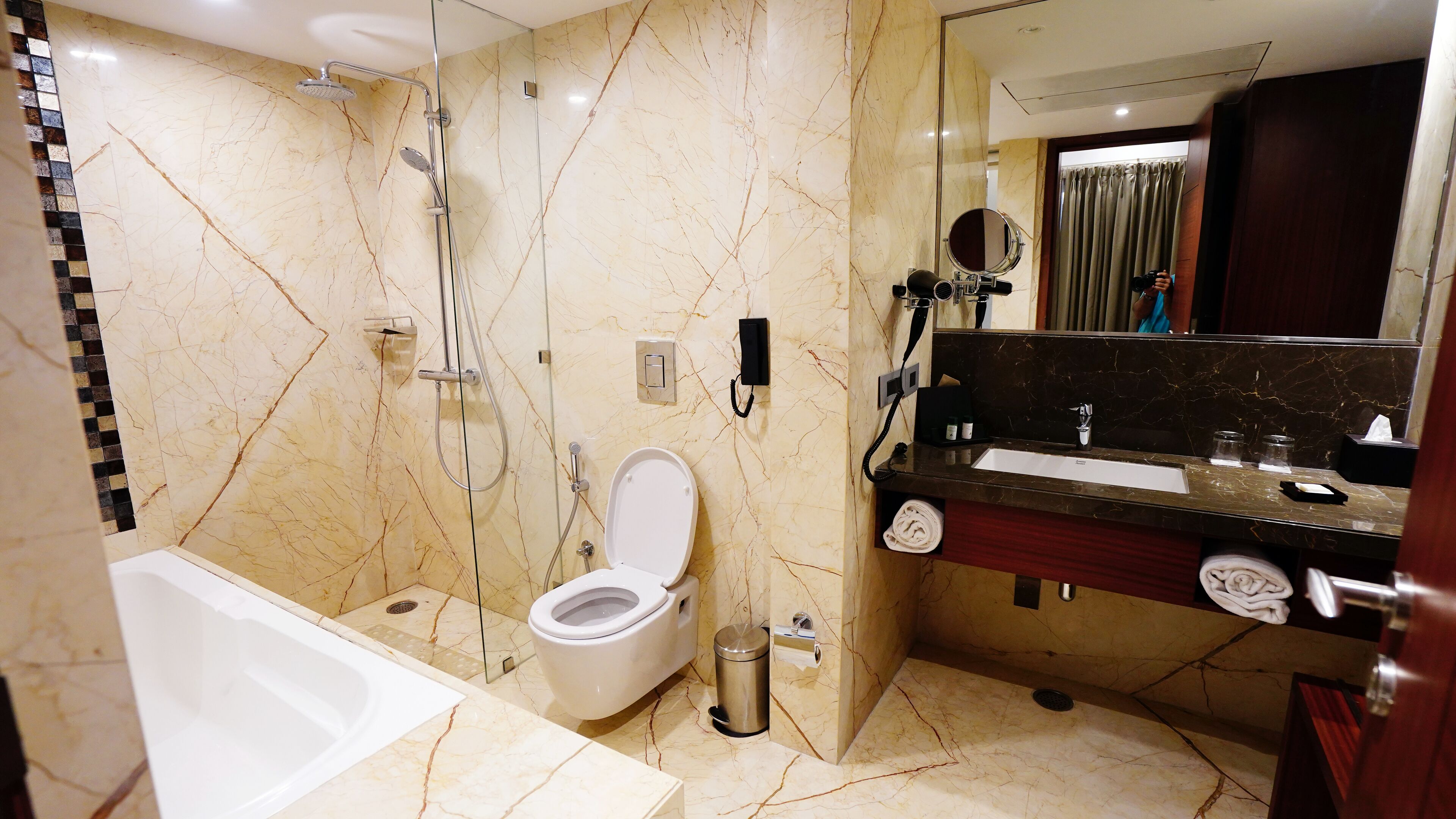 A modern bathroom with a bathtub, toilet, and shower area.
