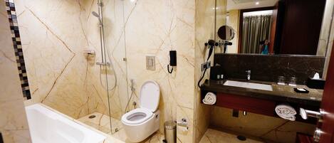 A modern bathroom with a bathtub, toilet, and shower area.