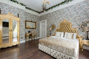 Una camera da letto con un letto grande, una toeletta con specchio, una scrivania e un armadio.