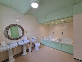A bathroom with a sink, toilet, and a large bathtub.