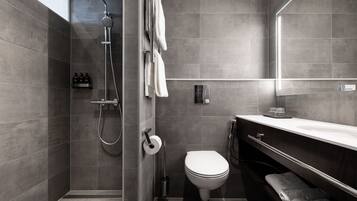 A modern bathroom with a shower, toilet, and vanity.