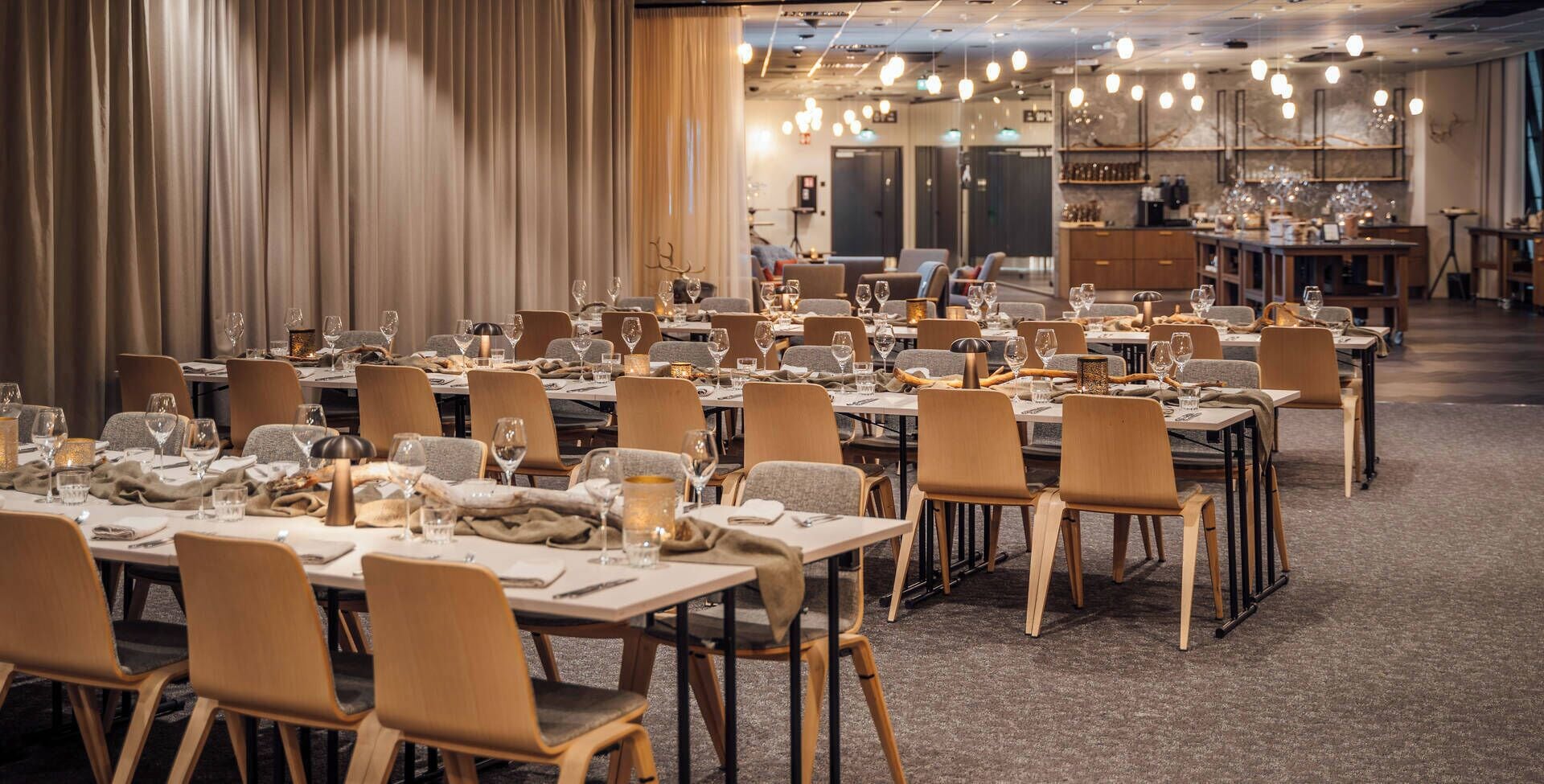 A spacious dining area with multiple tables set for dining, each with chairs and wine glasses.