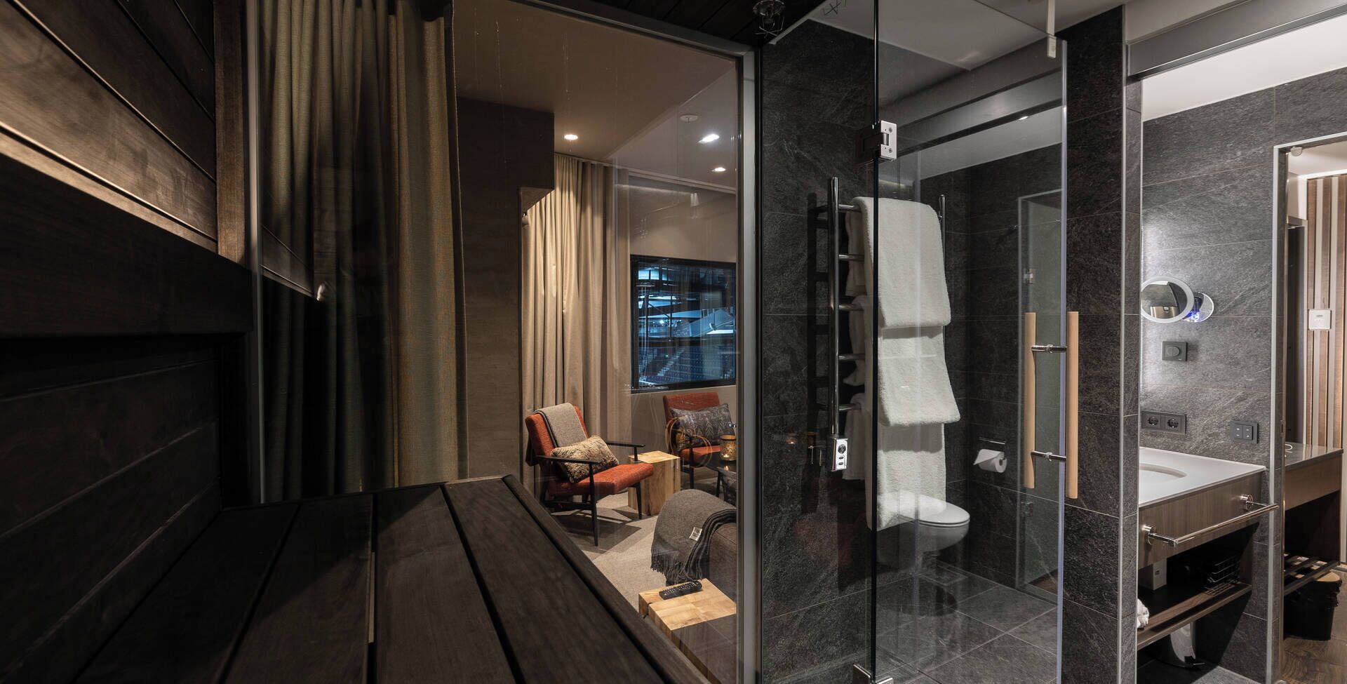 A modern bathroom with a glass shower enclosure, a toilet, and a sink.