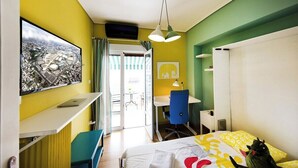 A hotel room with a bed, a desk, a chair, a television, and a view through a door. - Dimitsanas25-Startupper's Pad in real Athenian nei (Athens)