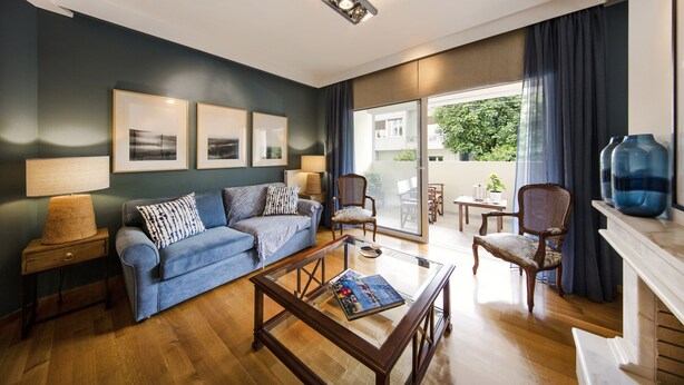 Un salon moderne avec un canapé bleu, une table basse en verre et une cheminée.