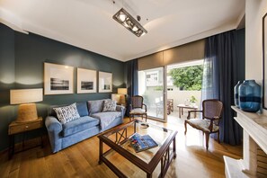 Un salon moderne avec un canapé bleu, une table basse en verre et une cheminée.