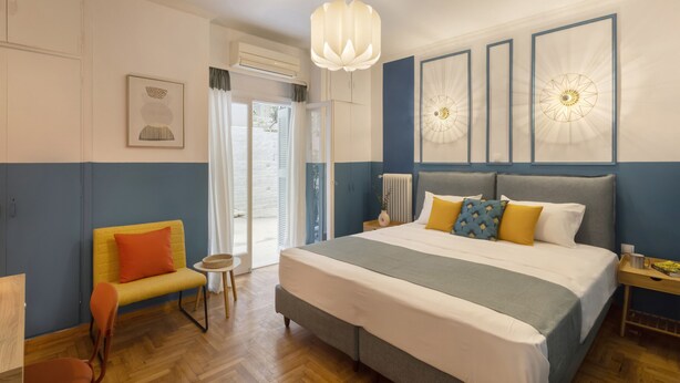 Ein Schlafzimmer mit einem großen Bett, einem Sessel, einem kleinen Tisch und einer Heizung.