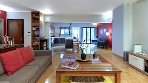 Ein modernes Wohnzimmer mit Sofa, Couchtisch und einer Küche im Hintergrund.