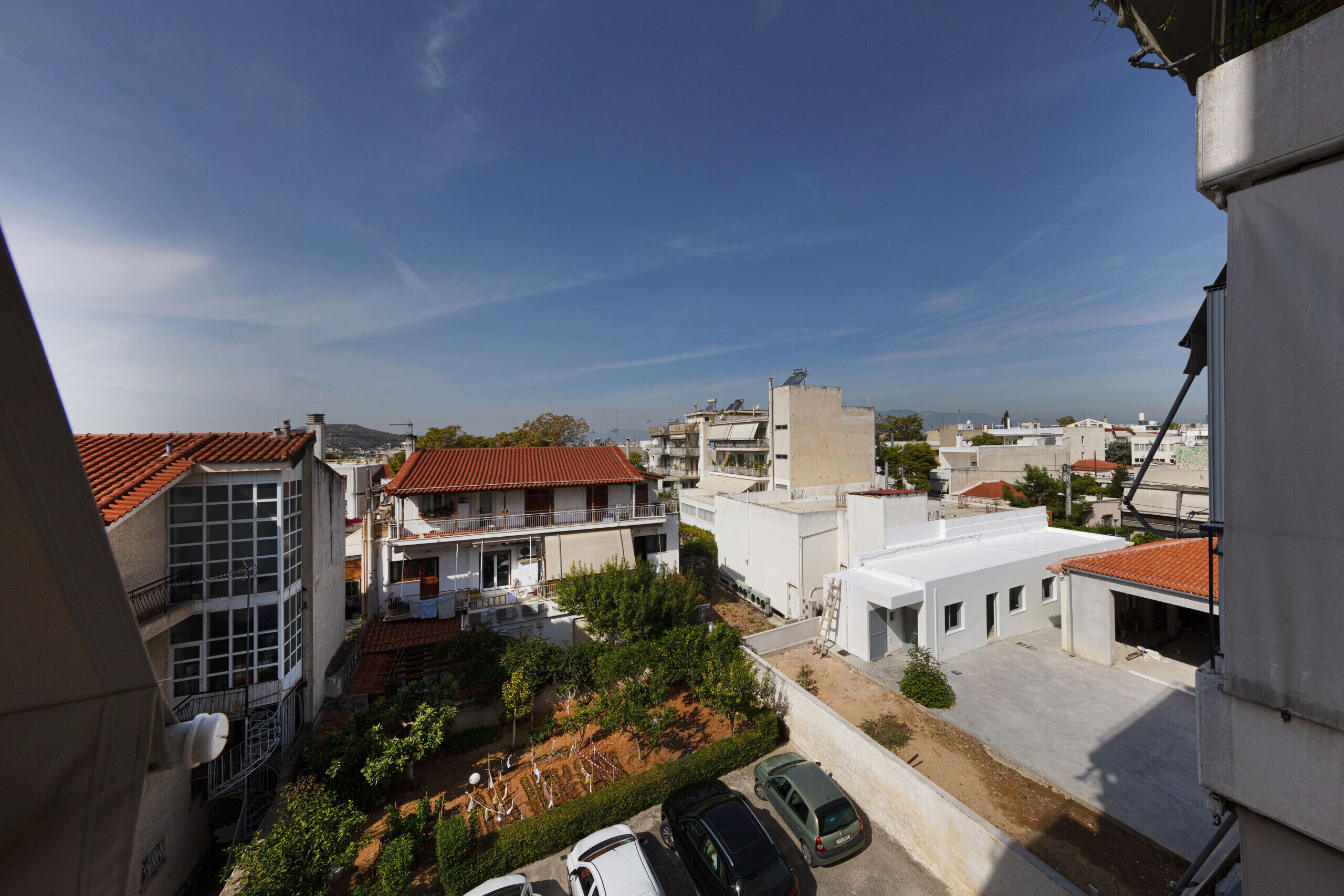 A residential area with buildings, a parking lot, and a clear sky.