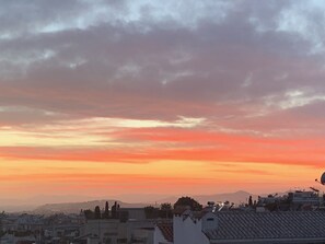 En stadsbild i solnedgången med byggnader och en klar himmel.