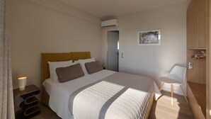 A bedroom with a bed, bedside tables, a chair, and a door. - Ippodamou 25- Acropolis view renovated apartment (Athens)