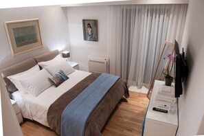 A neatly arranged bedroom with a bed, bedside table, lamp, and a mirror. - Michalakopoulou94 · Katia Modern Apartment in Athe (Athens)