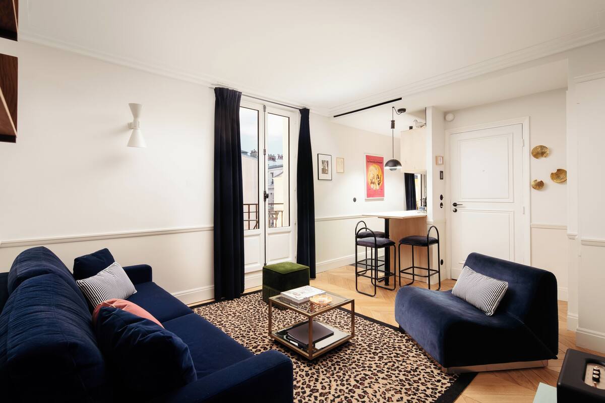 A modern living room with a sofa set, a coffee table, and a dining area with chairs.