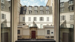 A building with a central entrance, multiple windows, and a balcony with a wrought iron railing. - My Maison In Paris - Champ de Mars (Paris)