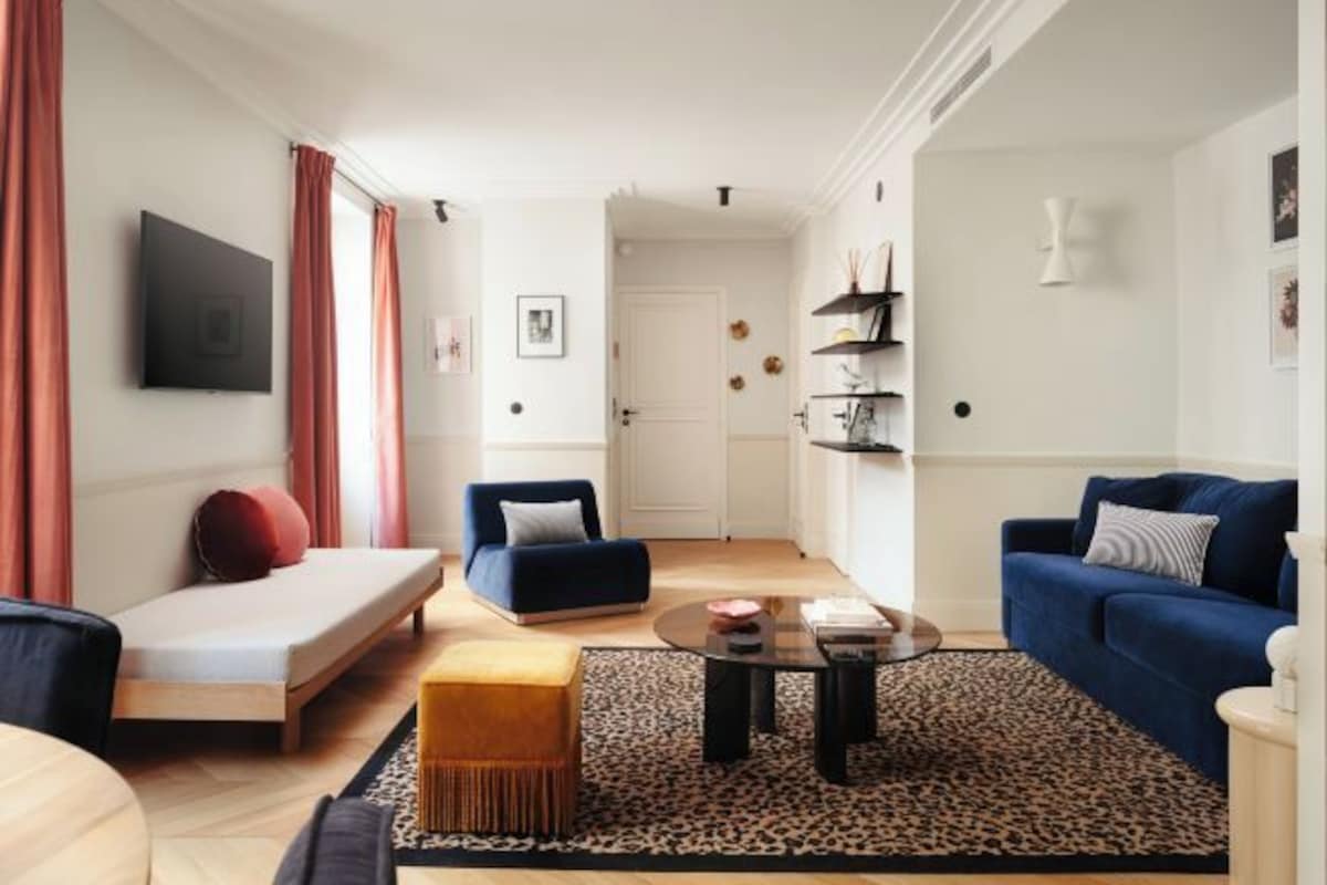 Un salon moderne avec un canapé, un fauteuil et une table basse.