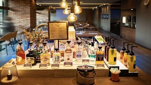 Een bar met diverse alcoholische flessen en een menubord.