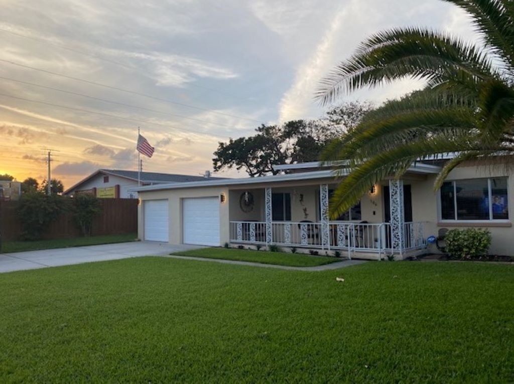A single-story house with a front porch, a garage, and a well-maintained lawn.