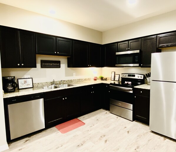 Enjoy cooking in this fully equipped kitchen with a dishwasher, sink, stove, and refrigerator.