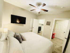Relax in comfort with a large bed, ceiling fan, and flat-screen TV.