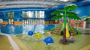An indoor swimming pool with a slide and play structures. - Beautiful and Tranquil Lakeside Lodge - Sleeps 5 (Northampton)