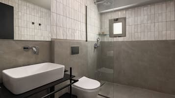 Ein modernes Badezimmer mit Waschbecken, Toilette und Duschkabine aus Glas.