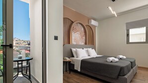 A bedroom with a bed, bedside table, and a view of the outside. - Santa Maria City Hotel (Rhodes)