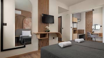 Una habitación de hotel moderna con una cama grande, un televisor, un escritorio con una silla y un espejo.