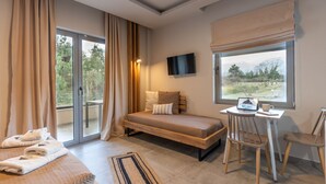 A bedroom with a bed, a desk, a chair, a TV, and a window with a view of trees and mountains. - Olympus Pantheon Luxury Rooms (Dio-Olympos)