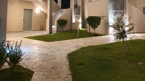 A modern building with multiple levels, a central staircase, and a well-lit entrance. - Olympus Pantheon Luxury Rooms (Dio-Olympos)
