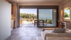 Un intérieur moderne avec une grande porte-fenêtre coulissante donnant sur un patio extérieur.