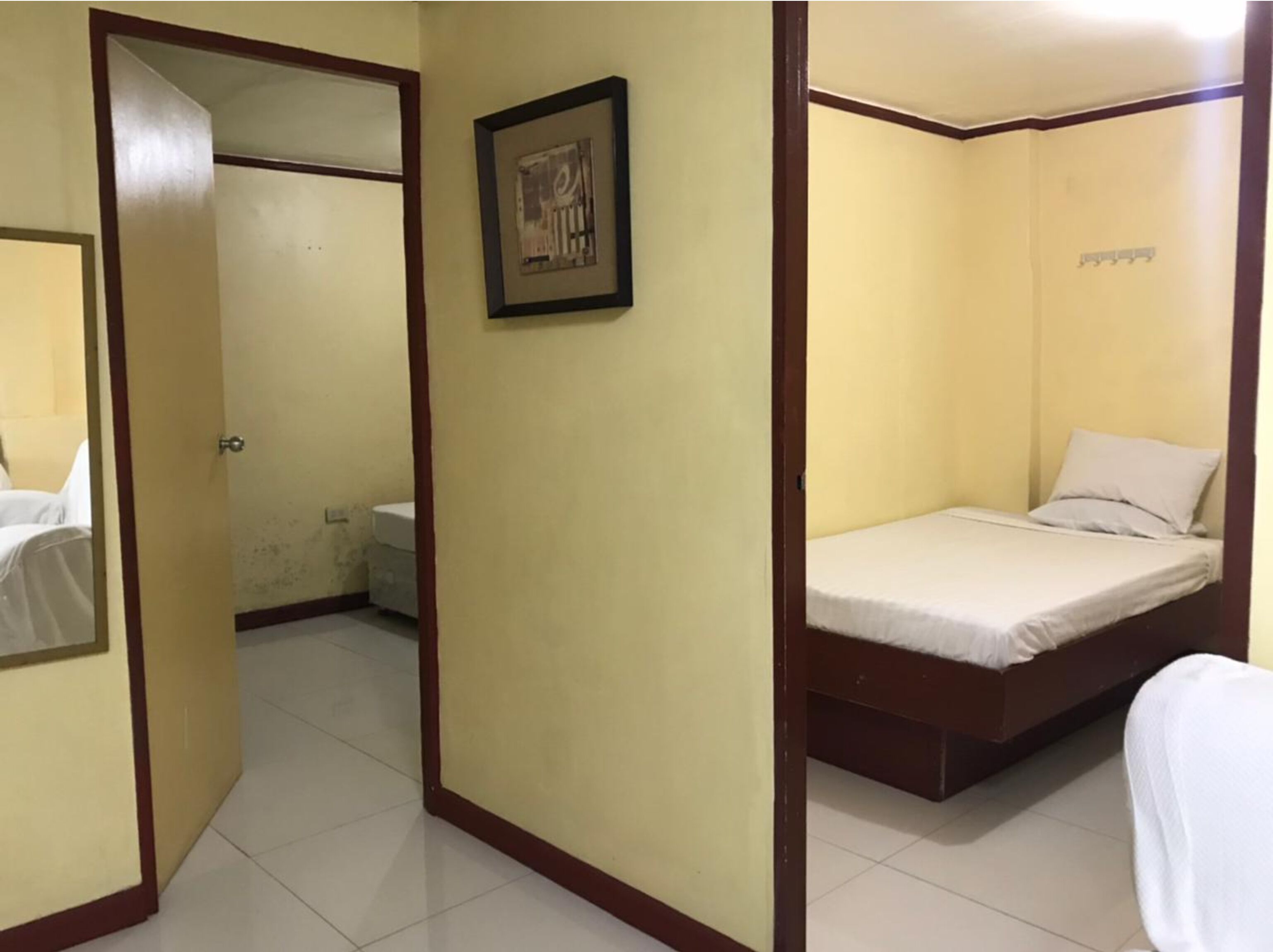 A room with a bed, a toilet, and a framed picture on the wall.
