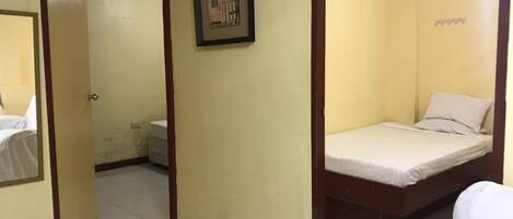 A room with a bed, a toilet, and a framed picture on the wall.