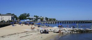 A beach with people, umbrellas, and a pier. - Blocks to the Boardwalk! (North Beach)