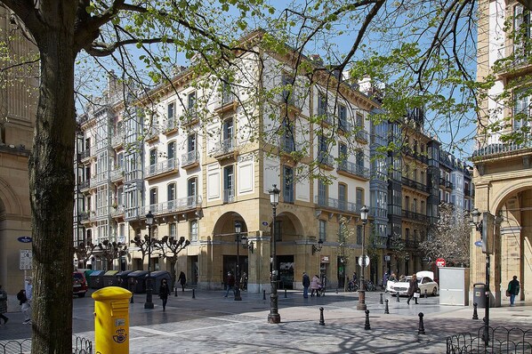 A historic European square with classical architecture, including a prominent archway and a tree-lined street. - Oiasso by FeelFree Rentals (Donostia)
