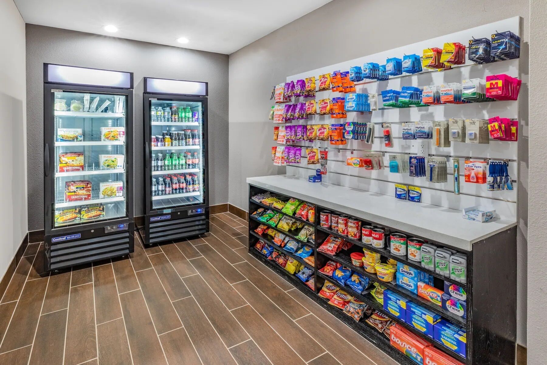 Zona de màquines expenedores de menjar i begudes, amb dos aparells refrigerats i una vitrina on es mostren diferents productes.