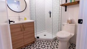 Un baño moderno con ducha, inodoro y lavamanos.