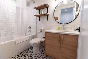 Een douche, handdoeken, zeep, toiletpapier