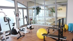 Een sportschool met cardioapparaten, gewichthefapparatuur en trainingsballen.