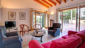 A spacious living room with a television, a coffee table, and seating areas. - Villa Llobiner, Perfect location! A country villa by Renthousing (Pollença)