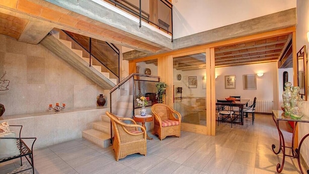 A spacious living area with a staircase, wicker furniture, and a dining area. - Villa Llobiner, Perfect location! A country villa by Renthousing (Pollença)